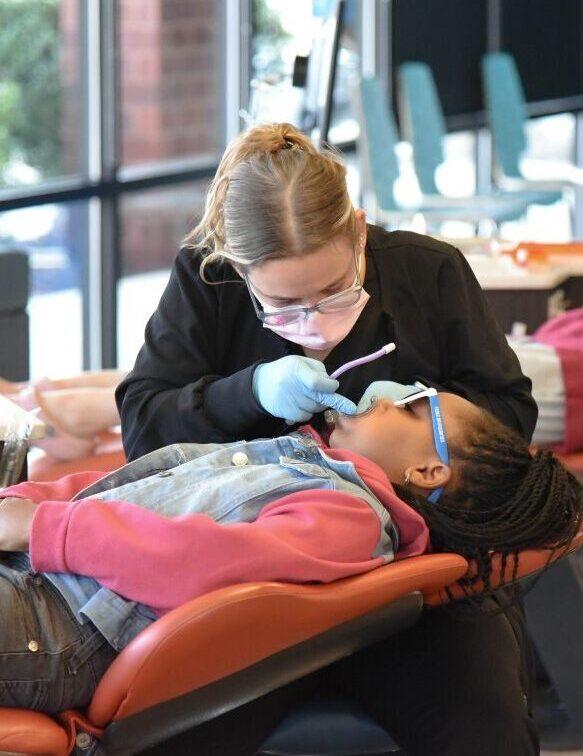 Orthodontic team member providing gentle chairside care to a child patient in a modern orthodontic office