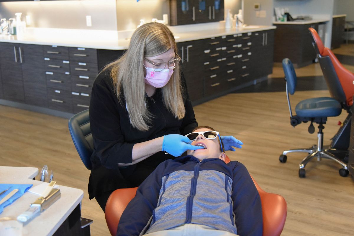 Orthodontic team member providing gentle care to a child patient in a comfortable treatment chair